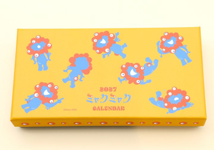 ミャクミャクのイラストが複数描かれた、黄色いカレンダーの箱
