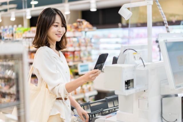 レジでポイントを使う女性
