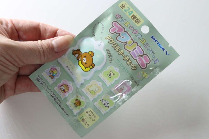 女性がサンエックスのアクリルキーチェーンのパッケージを手に持っている