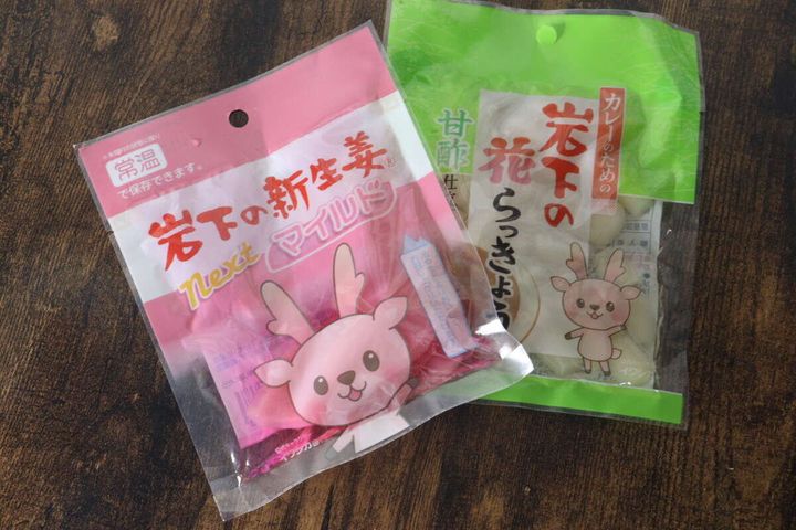 ピンクと緑のパッケージに入った岩下の新生姜と花らっきょうが並んで斜めに置かれている