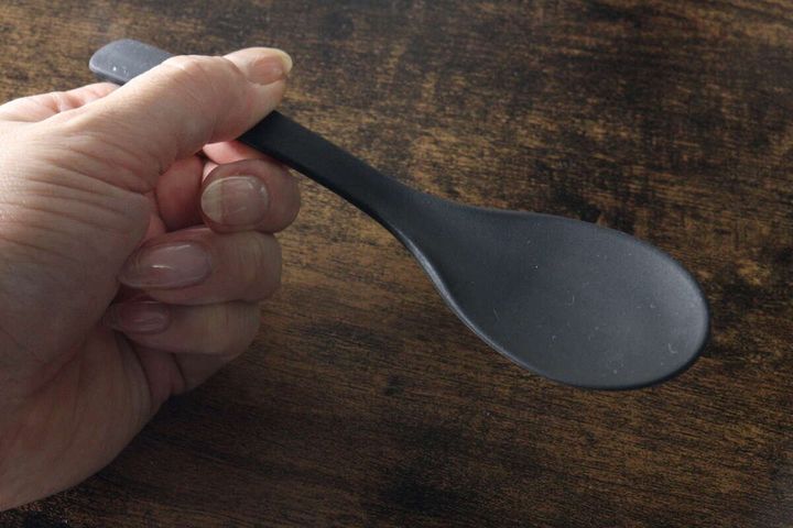 女性の指が黒いシリコーンスプーンを横から持っている