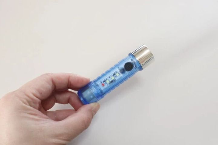 手に持った青いスケルトンデザインの充電式LEDライト