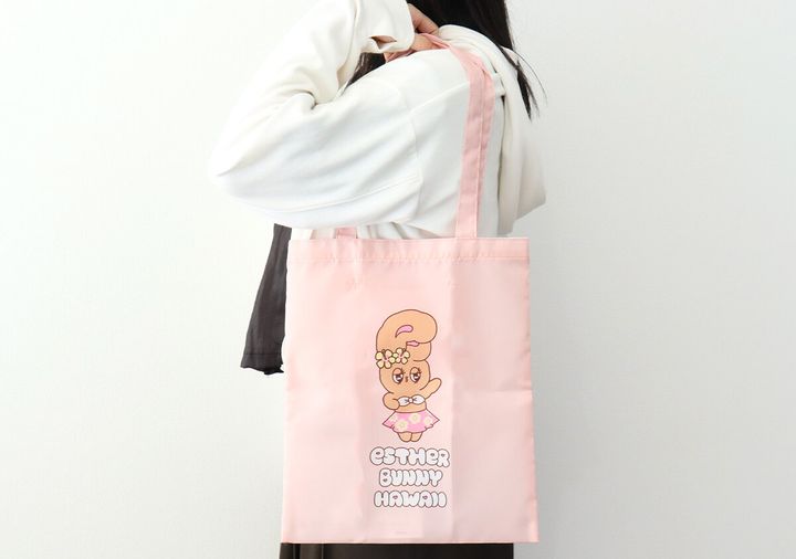 白いパーカーの女性がピンクのトートバッグを肩掛けしている後ろ姿