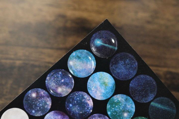 宇宙柄の丸いシールに透明なポイントシールを貼ってぷっくりさせた様子
