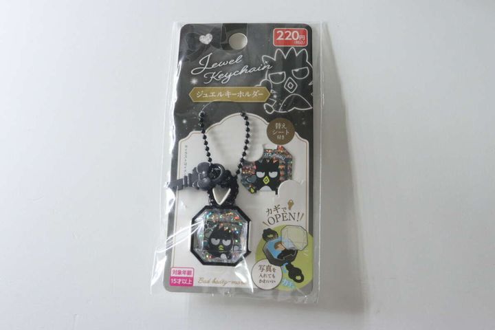 パッケージに入ったバッドばつ丸のジュエルキーホルダー。黒いオクタゴン型で鍵とボールチェーンが見える