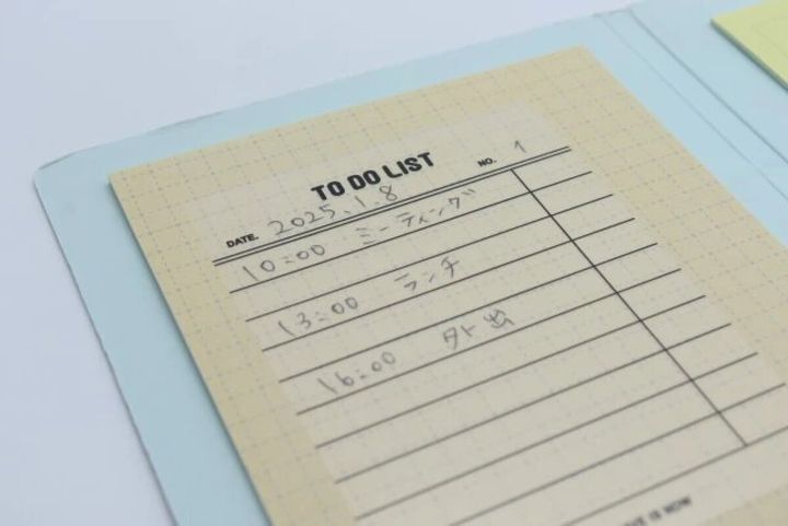 ノートに貼られた透明ふせんに予定が手書きされている