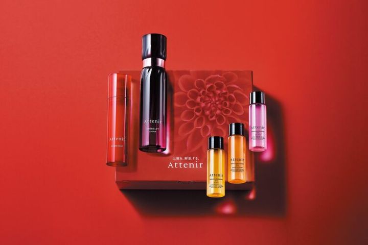 赤い背景に並ぶ、アテニアのスキンケア製品とミニサイズのボトル