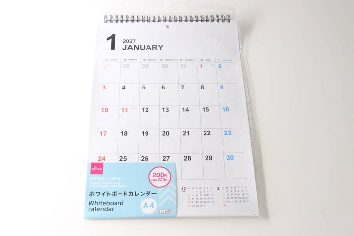 透明な袋に入ったダイソーのホワイトボードカレンダー。1月と商品情報が見える。