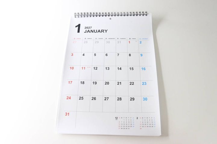 白い机に置かれたダイソーのホワイトボードカレンダー。1月のページが開いている。