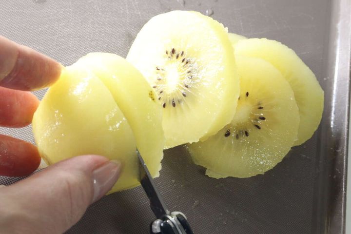 マルチツールのナイフで皮をむいたキウイをカットしている様子