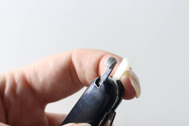 マルチツール本体からピンセットを引き出している指先