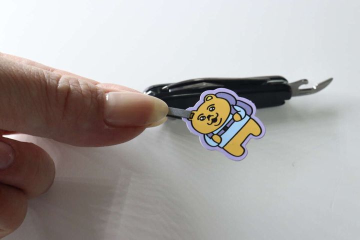 マルチツールのピンセットでクマのシールをつまんでいる様子