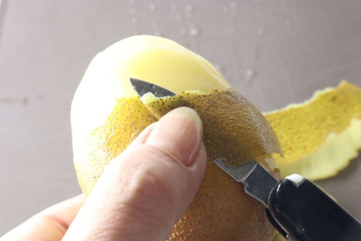 マルチツールのナイフでキウイの皮をむいている様子