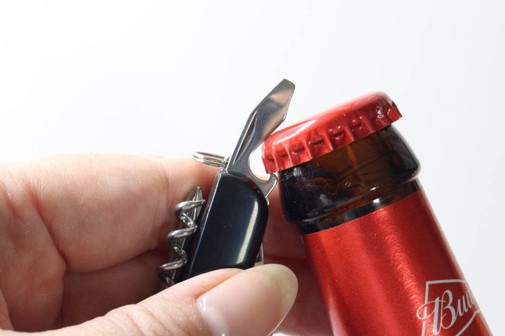マルチツールの栓抜きでビールの瓶の蓋を開けている様子