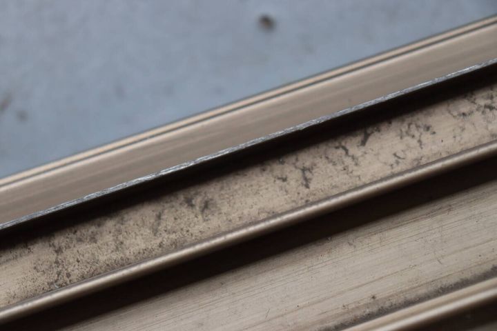 細かな粉状の汚れがびっしり溜まった窓のサッシのレール部分