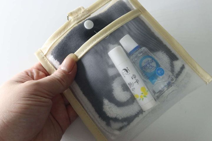 メッシュハンカチポーチにリップクリームと目薬、ハンカチが入っている様子。