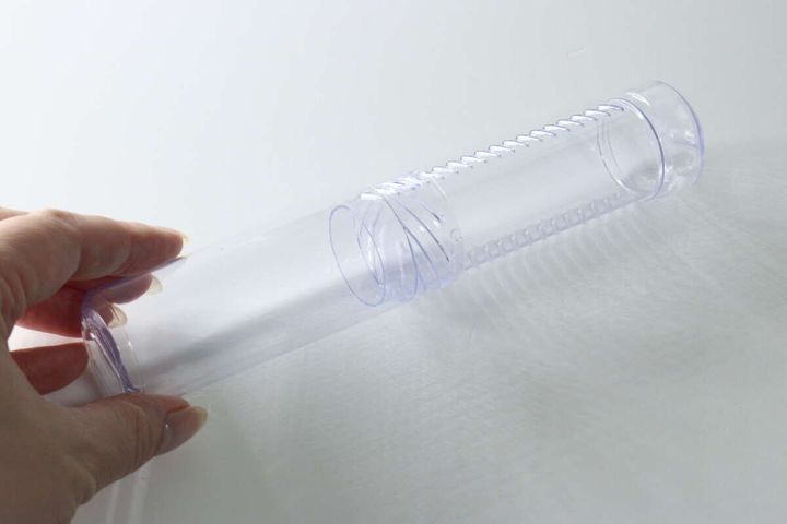 女性の手が透明なスクリューケースを一番長く伸ばした状態で持っている。