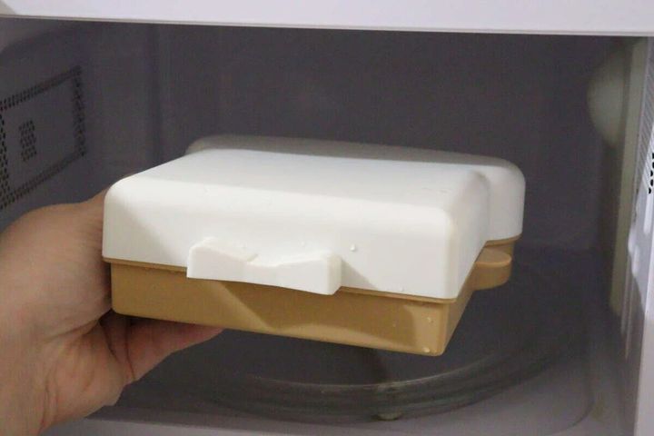 食パン型の電子レンジ調理器を電子レンジに入れている手元