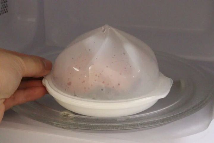肉まん用電子レンジ調理器に肉まんを入れ、蓋をして電子レンジに入れている手元