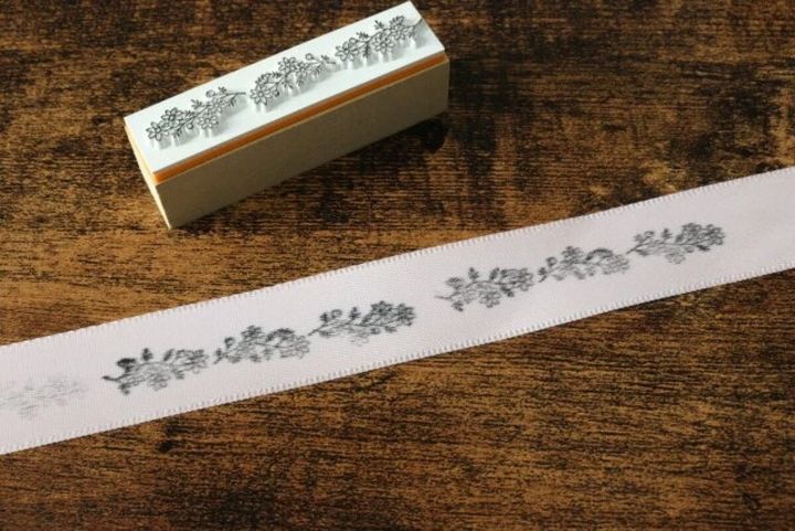 ボタニカル柄のスタンプで白いリボンに模様が押されている様子