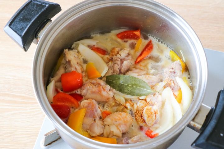 鶏もも肉とパプリカをコンソメで煮る様子