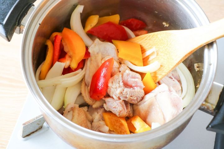 鶏もも肉とパプリカ、玉ねぎを炒める様子