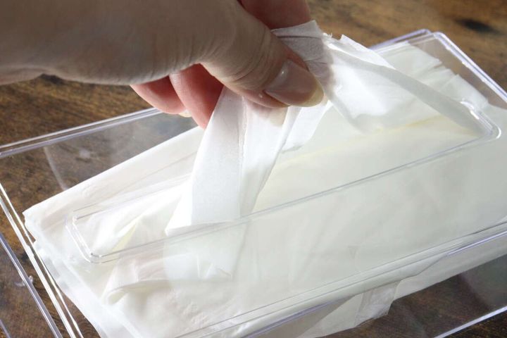 女性の手がティッシュケースからティッシュをスムーズに取り出している様子