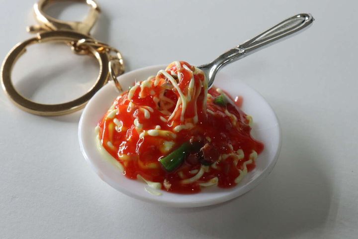 フォークに絡まったパスタの食品サンプルキーホルダーのクローズアップ