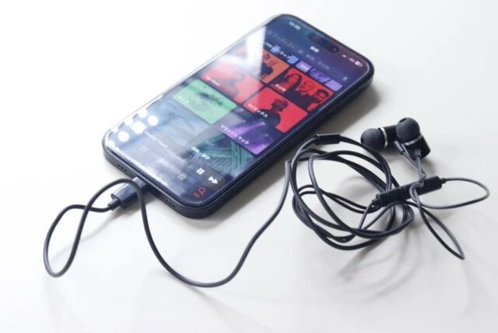 スマートフォンにType-Cイヤホンが接続され音楽再生画面が表示されている