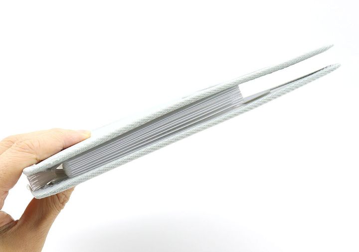 グレーのコクヨお薬ファイルを横から見た、スリムな状態を掴む手元