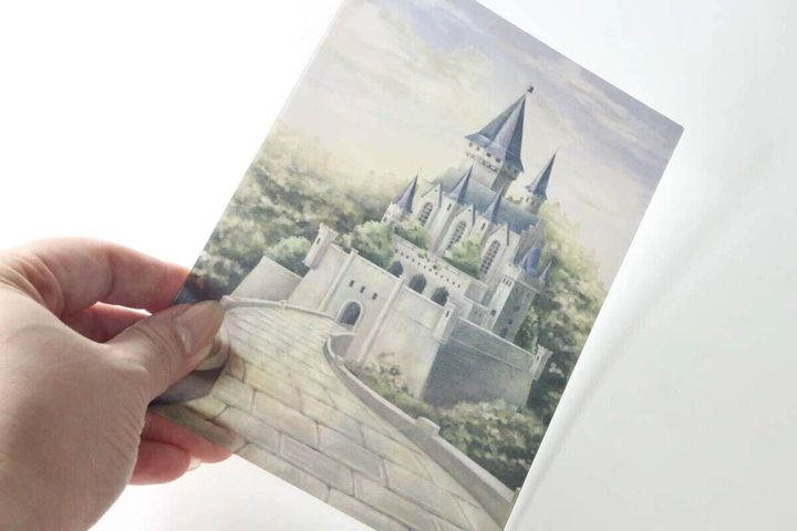 手に持たれたレンチキュラーアートの昼間のお城の絵柄