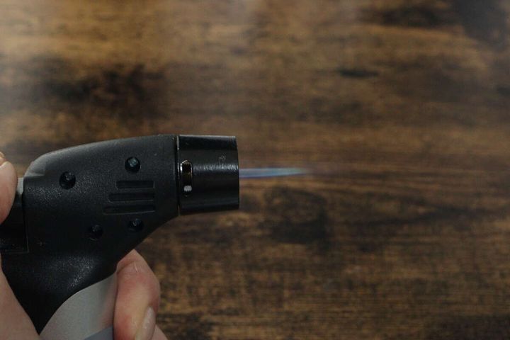 手がダイソーのガスバーナーを持ち火力最大で炎が出ている様子
