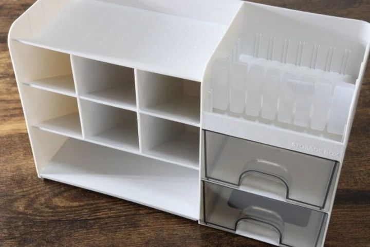 白い多機能引き出しケースが木目のテーブルに置かれている。右側に引き出し、左側に棚がある