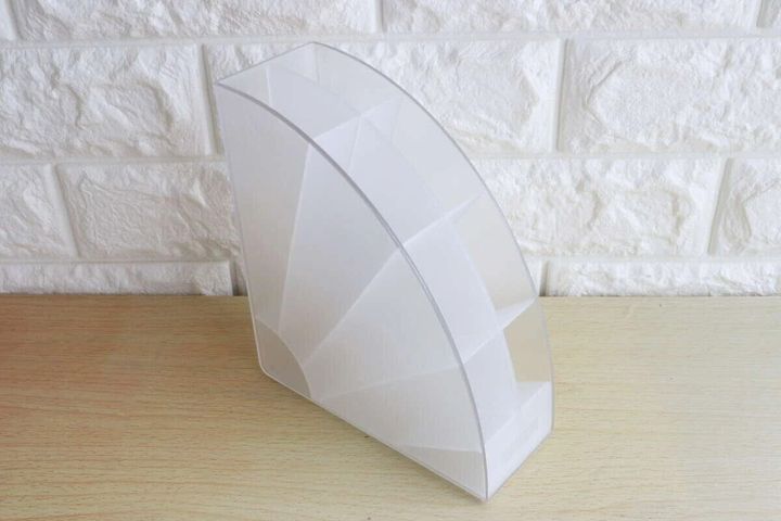 白いアーチ型デスク収納スタンドが木目のテーブルに置かれている。背景は白いレンガ調の壁