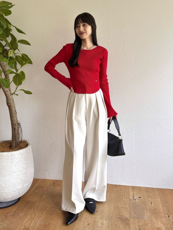 赤い長袖ニットと白いワイドパンツのコーデ
