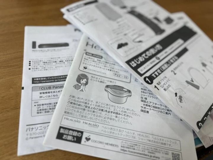 家電製品の取扱説明書が数冊重なって置かれている