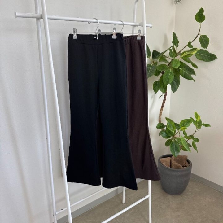 黒と茶色のフレアパンツがハンガーラックに吊るされている