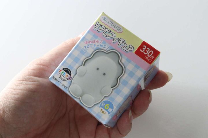 女性の手のひらに乗せられた求心フレンズソフビフィギュアのパッケージ