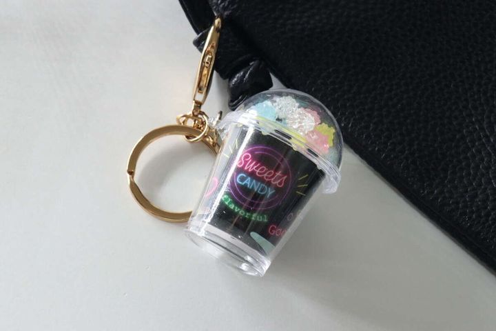 黒いバッグの持ち手に付けられたお菓子カップ型キーホルダー