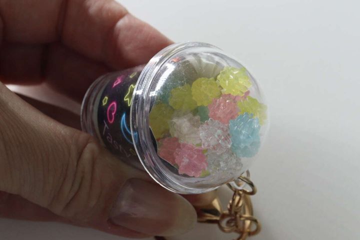 横倒しにしたカップ型キーホルダーの中に見えるカラフルな金平糖