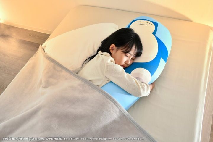 カビゴン柄の抱きまくらを使う様子