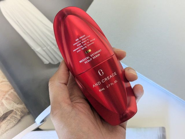 アンド クレアージュ メディカルエストロジー スカルプセラムを手に持った様子