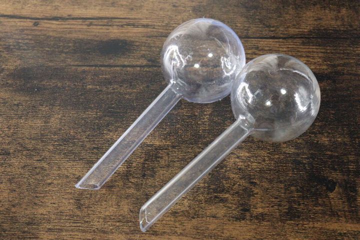 木目調のテーブルに置かれた透明な鉢用ウォーターディスペンサー2個