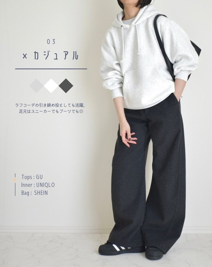 ライトグレーのパーカーとダークグレーのバレルパンツを着用し、カジュアルに着こなす女性