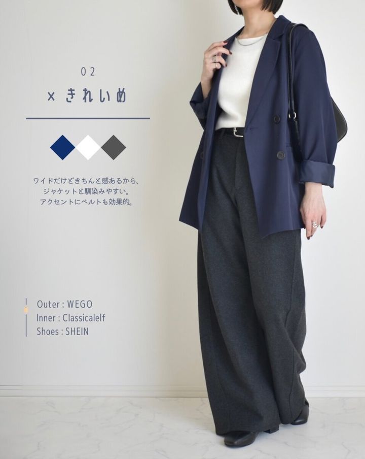 ネイビーのジャケットと白インナー、黒ベルトでダークグレーのバレルパンツを着こなす女性
