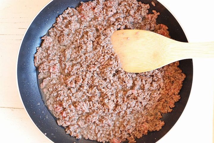 フライパンで合いびき肉を木べらでほぐしながら炒めている調理中の俯瞰写真