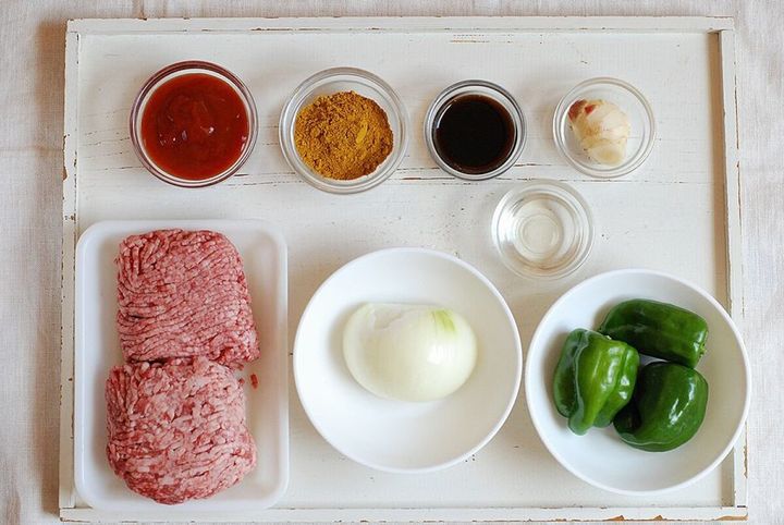 ピーマンドライカレーの材料であるひき肉、野菜、調味料が白いトレイに並べられた俯瞰写真