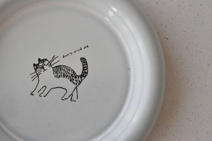 プレートの中央に描いた歩く猫のイラスト