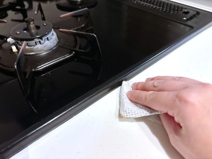 手順3．トイレットペーパーの芯をコンロまわりの隙間に差し込み、汚れをこすり落とす