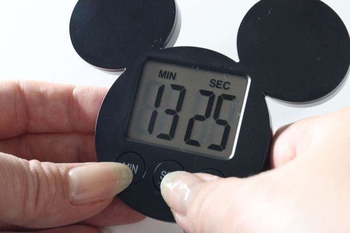 指でタイマーの「MIN」と「SEC」ボタンを同時に押している様子